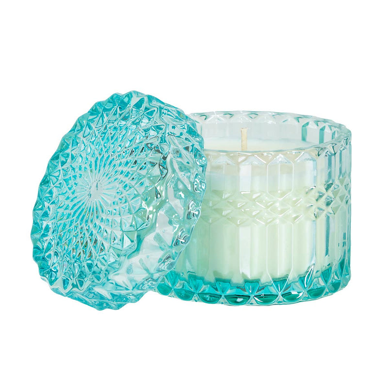 Tropical Breeze 8oz Petite Shimmer Candle in a light-blue diamond-cut glass jar, glowing with a soft shimmer. Infused with the exotic scent of citrusy Yuzu and tropical Tiger Lily, this luxury soy wax candle evokes a beachside escape. Perfect for home décor, relaxation, and gifting.