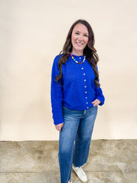Woman wearing a royal blue cardigan and dad jeans.