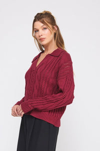 Woman wearing a burgundy sweater with a white background