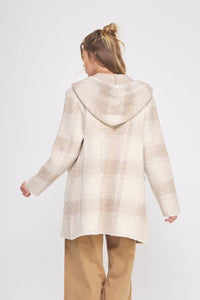 Person wearing a beige hooded coat on a white background