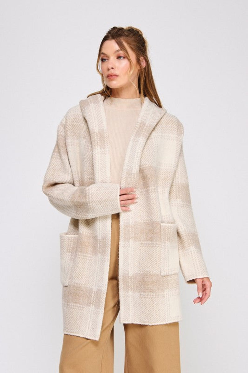 Woman wearing a beige plaid coat on a white background
