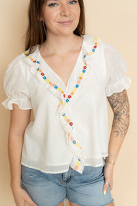 Women's white embroidered ruffle blouse paired with denim shorts a cute casual boho outfit