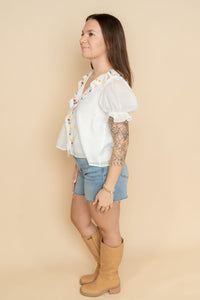White ruffled embroidered blouse for women, paired with jean shorts and boots for a cute boho outfit for women