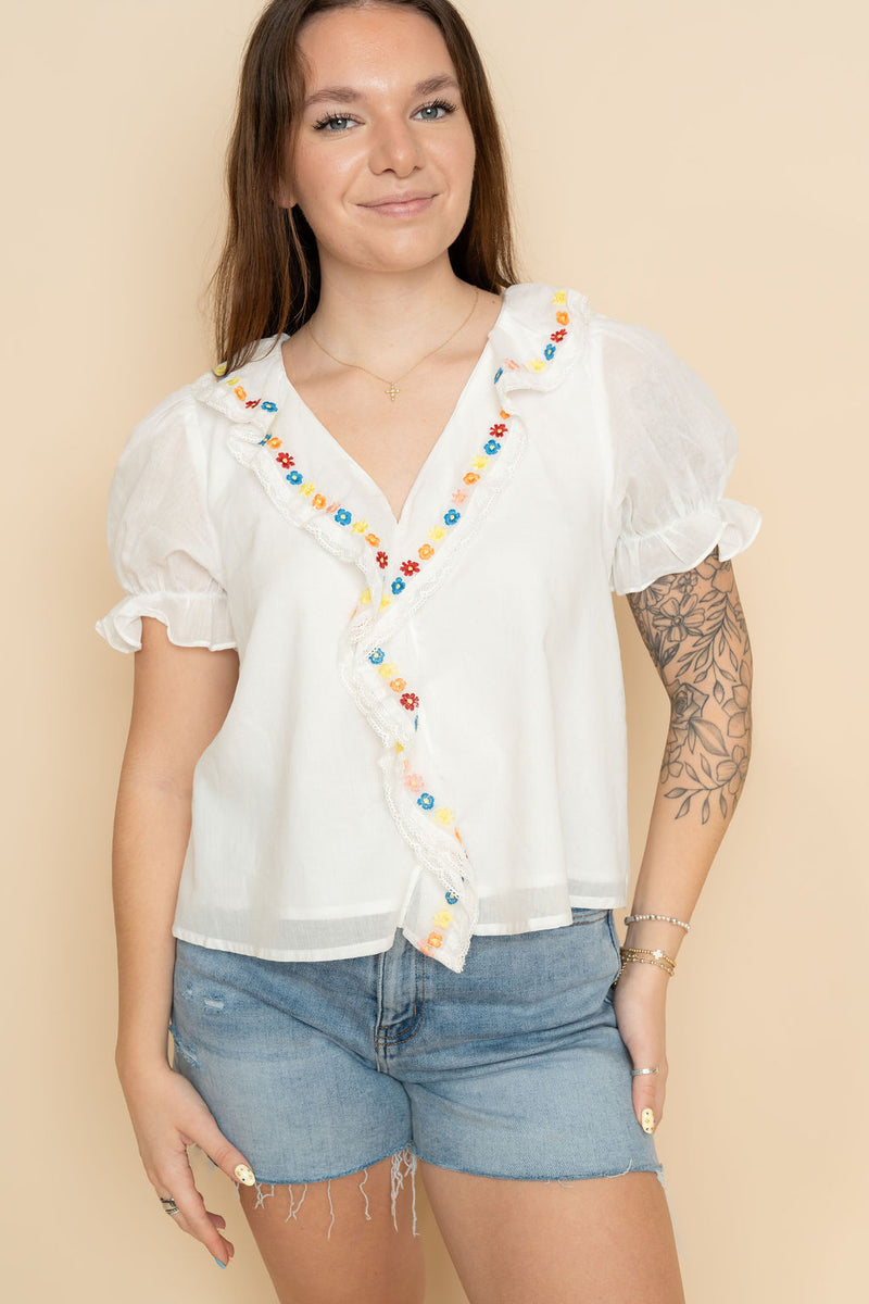 White ruffled embroidered blouse for women, paired with denim shorts for a boho summer outfit