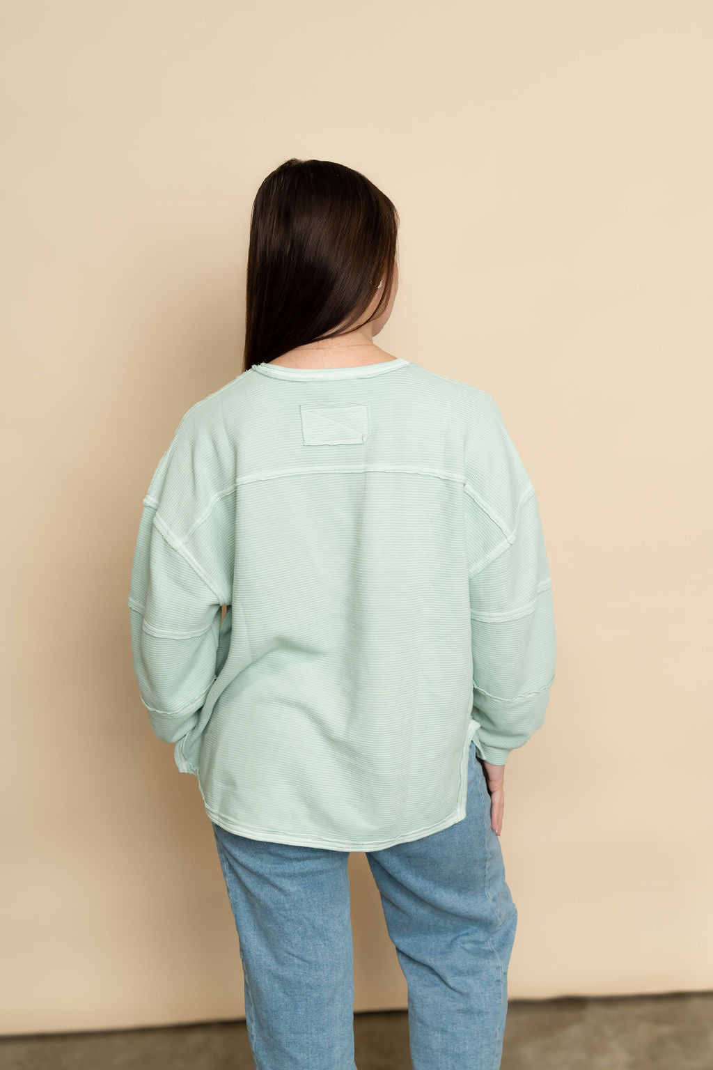 Back view of mint long sleeve top for women. 