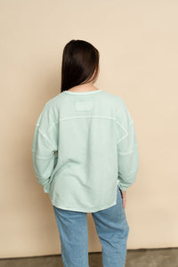 Back view of mint long sleeve top for women. 