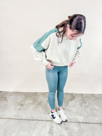 Green Contrast stitch sweatshirt in green paired with leggings for a casual spring outfit. 