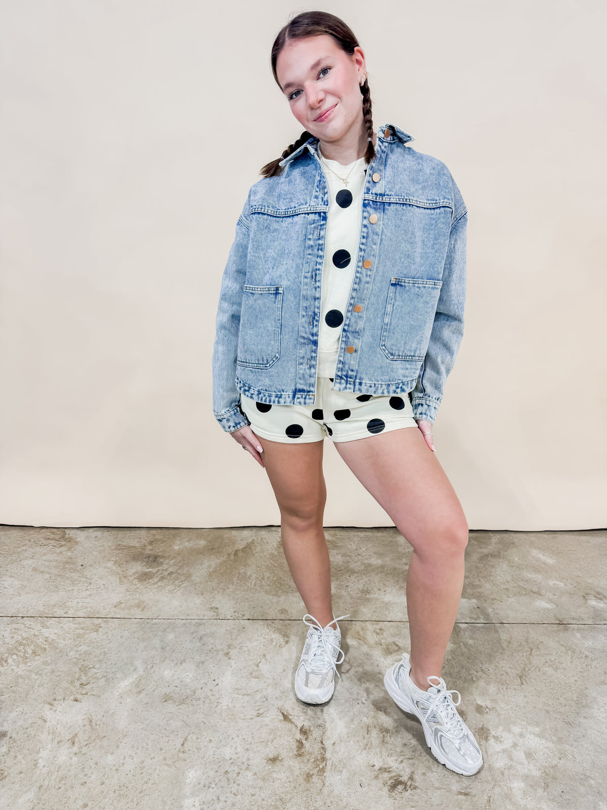 Light wash denim jacket paired over a polka dot set for a cute casual women's spring outfit. 