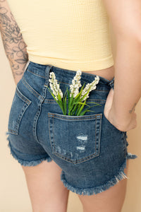 Back of distressed denim jean shorts for women in a dark wash