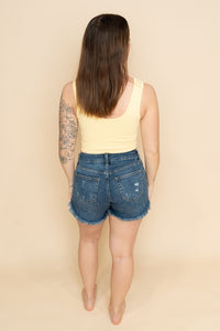 Back view of distressed dark wash denim shorts for women