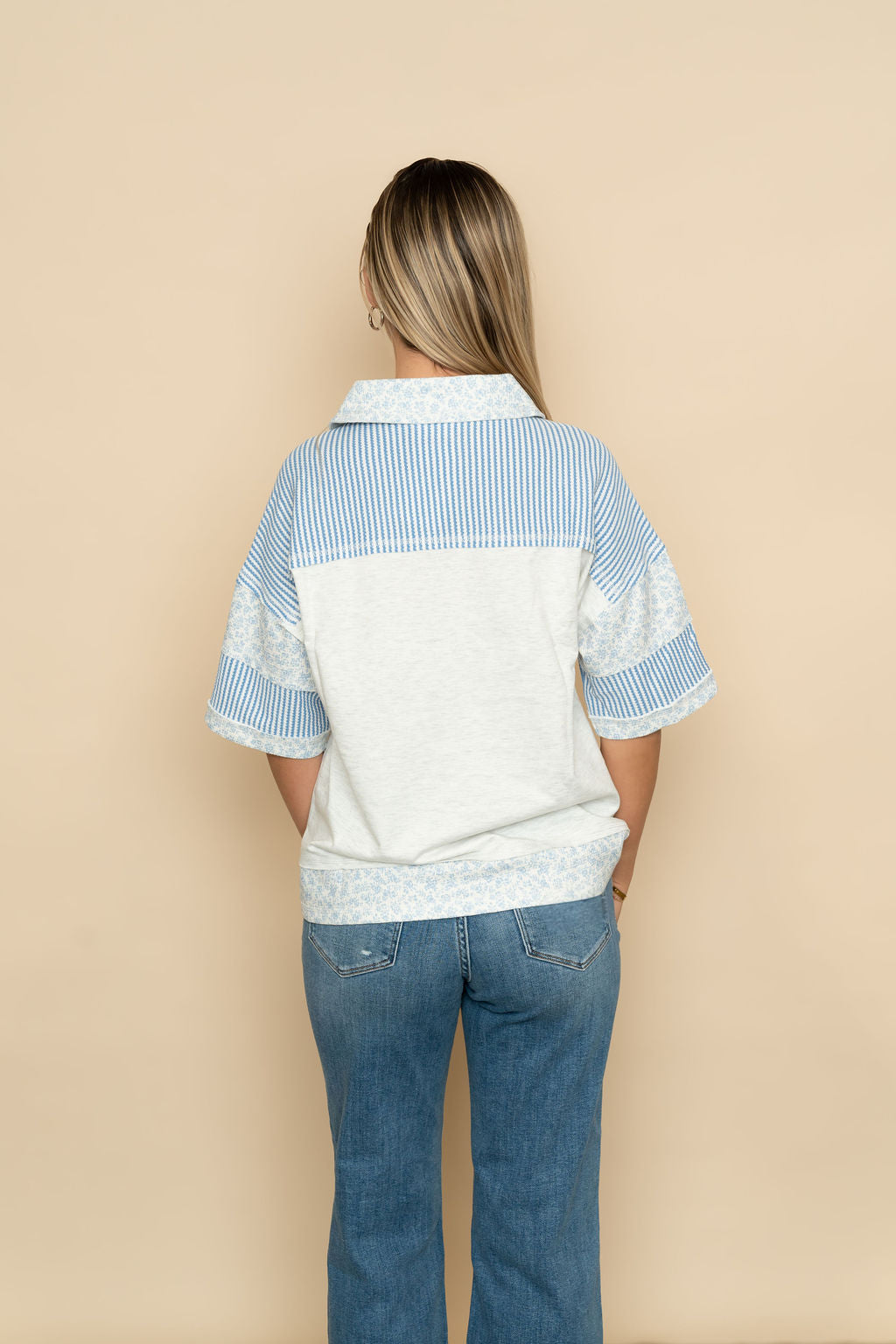 Back view of Heather gray and blue floral henley short sleeve top. 