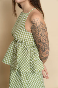 Side view of sage green gingham baby doll tank top. 