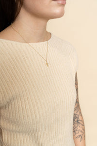 Closeup of cream knit short sleeve sweater for women. 