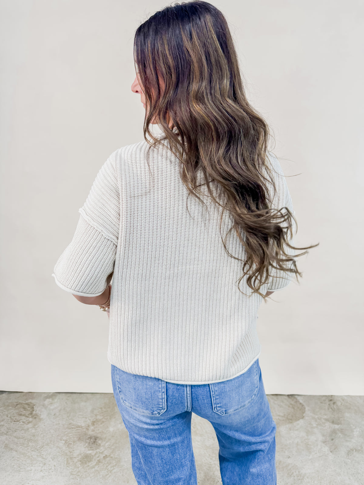 Back view of Ivory knit short sleeve sweater. 