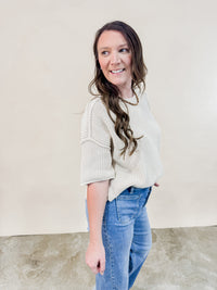 Side view of Ivory knit short sleeve sweater. 