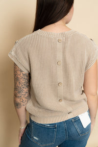 Closeup of back of beige knit short sleeve sweater with button detail back. 