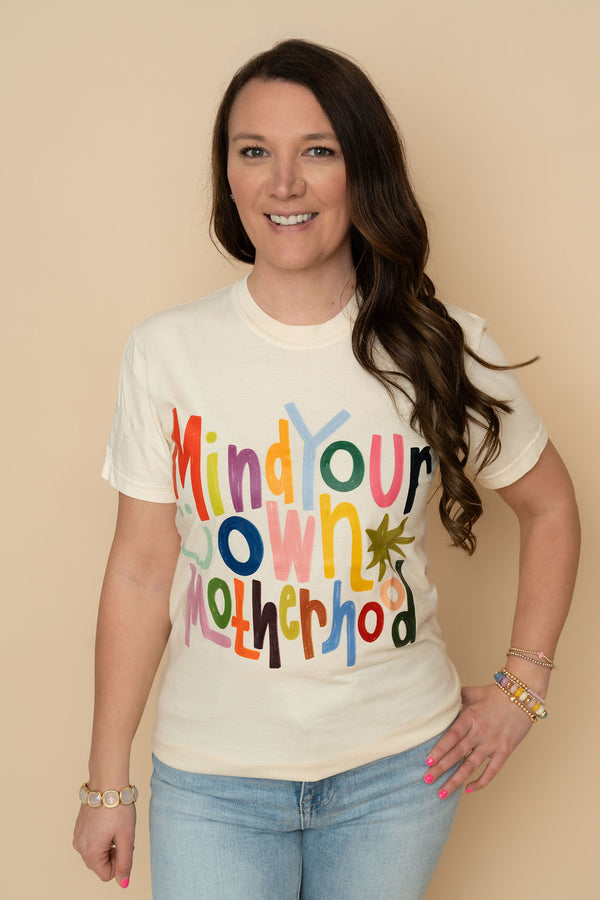 Ivory Comfort color tee with printed graphic Mind Your Own Motherhood in colorful writing. 