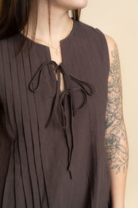 Closeup of brown tie front pleated romper for women. 