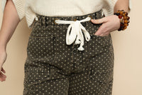Closeup of polka dot barrel jeans with tie waist. 