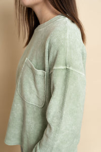 Closeup of ribbed long sleeve top in sage. 