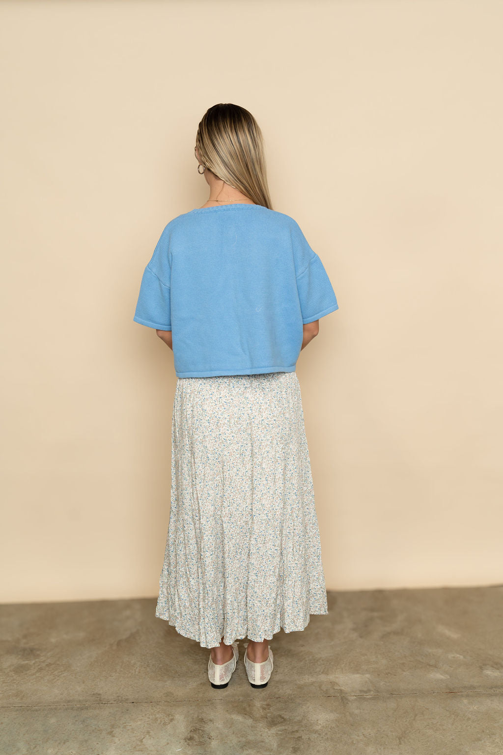 Back view of short sleeve cardigan in blue paired with floral maxi skirt for a casual and cute spring women's outfit. 