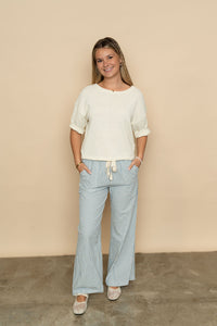 Ivory short sleeve knit sweater top paired with striped casual pants for a cute casual spring outfit. 