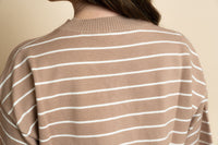 Closeup of brown and white striped sweater top. 