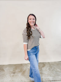 Brown and ivory short sleeve sweater paired with cuffed denim jeans for a casual outfit. 