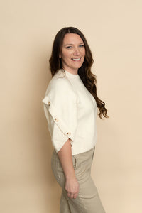 Side button details on short sleeve knit sweater in cream. 