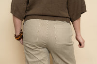 Closeup of brown and cream striped wide leg pants for women. 