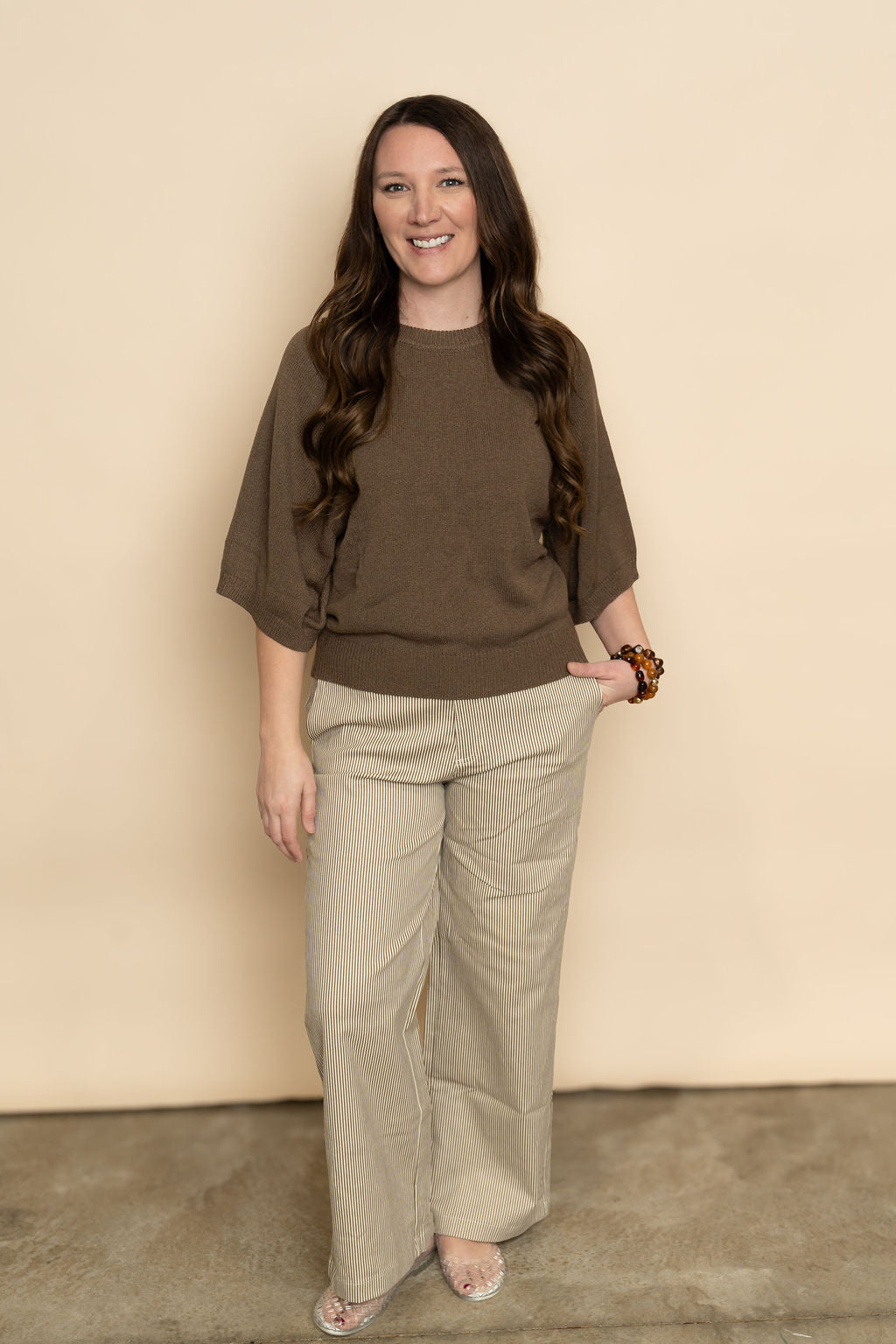 Brown and cream wide leg striped pants paired with brown short sleeve sweater for a casual outfit for women. 