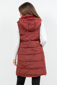 Red puffer vest worn by a person on a white background